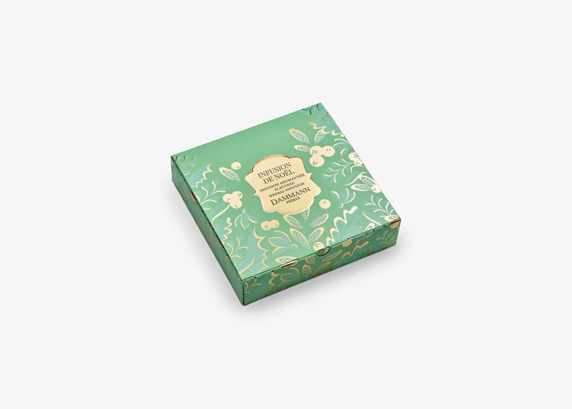 Étui Infusion de Noël Dammann Frères décoré d’un motif hivernal, contenant six sachets d’infusion aux épices et au chocolat.